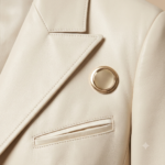 Close-up of cream blazer lapel with gold button