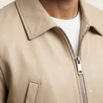 Close-up of beige zip jacket collar and front zipper worn over a white t-shirt