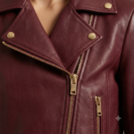 Close-up of burgundy biker jacket lapel with gold snap button and zipper
